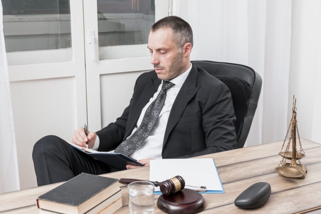Man reviewing paperwork at a desk with books and scales